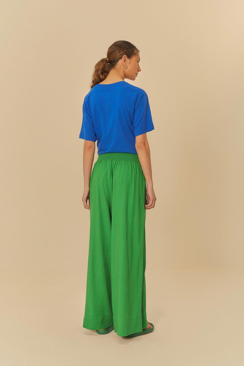 Vista trasera del pantalón verde con camiseta azul estampada.