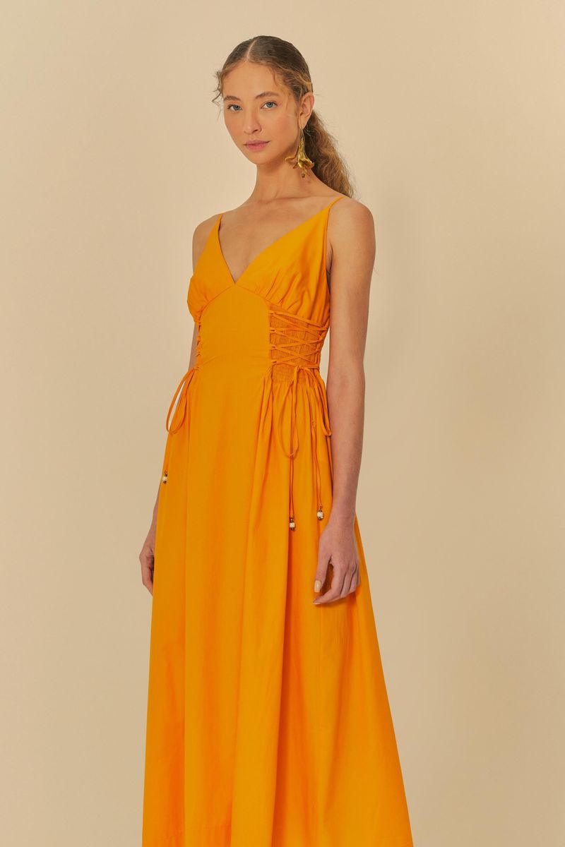 Modelo-de-perfil-usando-vestido-naranja-con-tirantes-finos.