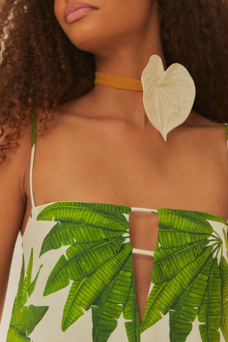 Vista trasera del vestido largo estampado con diseño de hojas verdes, destacando los tirantes delgados.