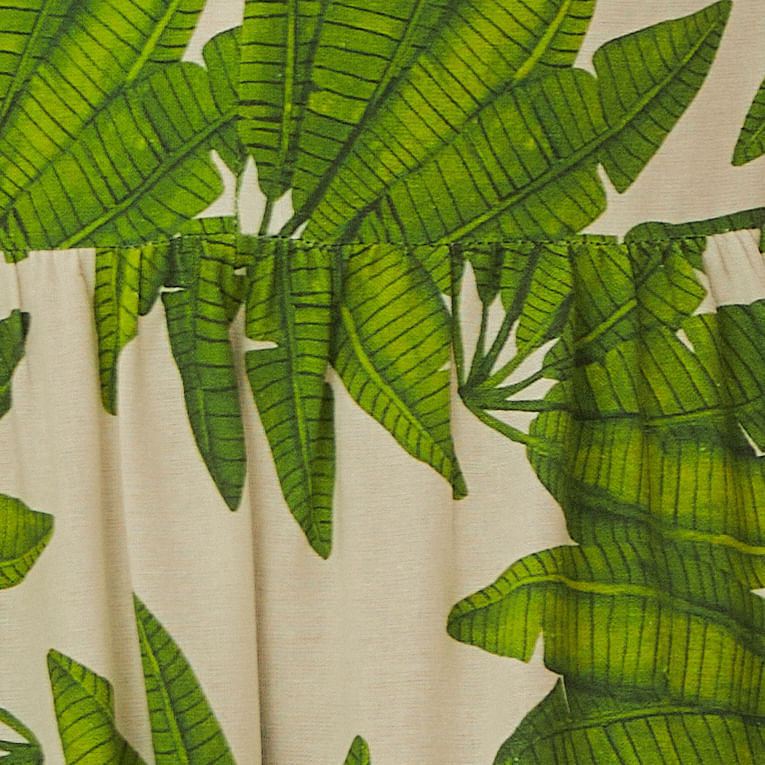 Detalle-del-borde-del-vestido-con-diseño-de-hojas-verdes-sobre-fondo-blanco.