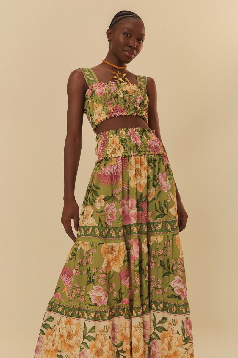 Falda larga estampada con motivos florales vibrantes, vista frontal con detalles de la cintura alta y capas.