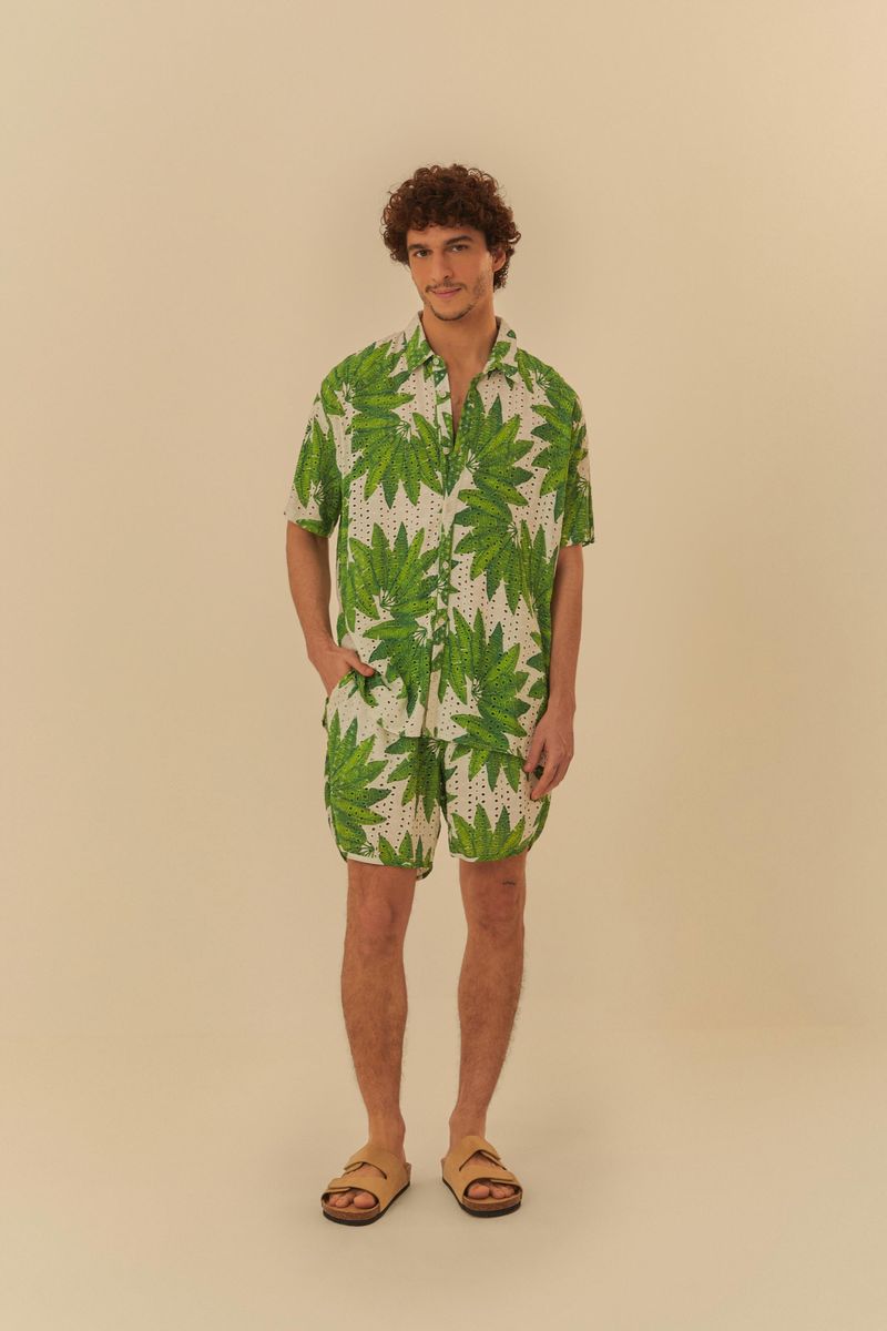 Modelo en pose frontal vistiendo camisa y pantalón corto estampado con diseño botánico de hojas verdes sobre fondo blanco.