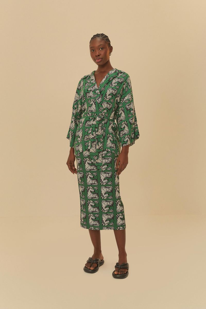 Persona con un vestido verde estampado de cebras y sandalias negras.