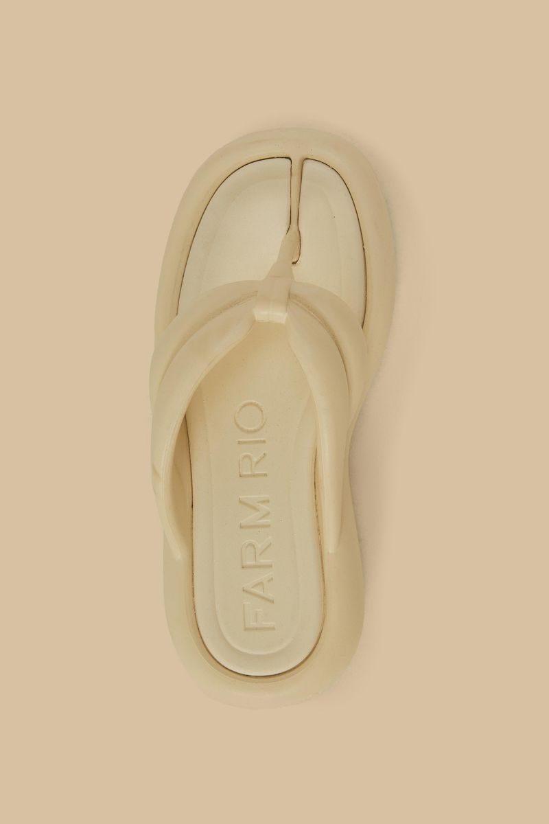 Imagen de un chancleta beige con diseño moderno y cómodo, visto de perfil.