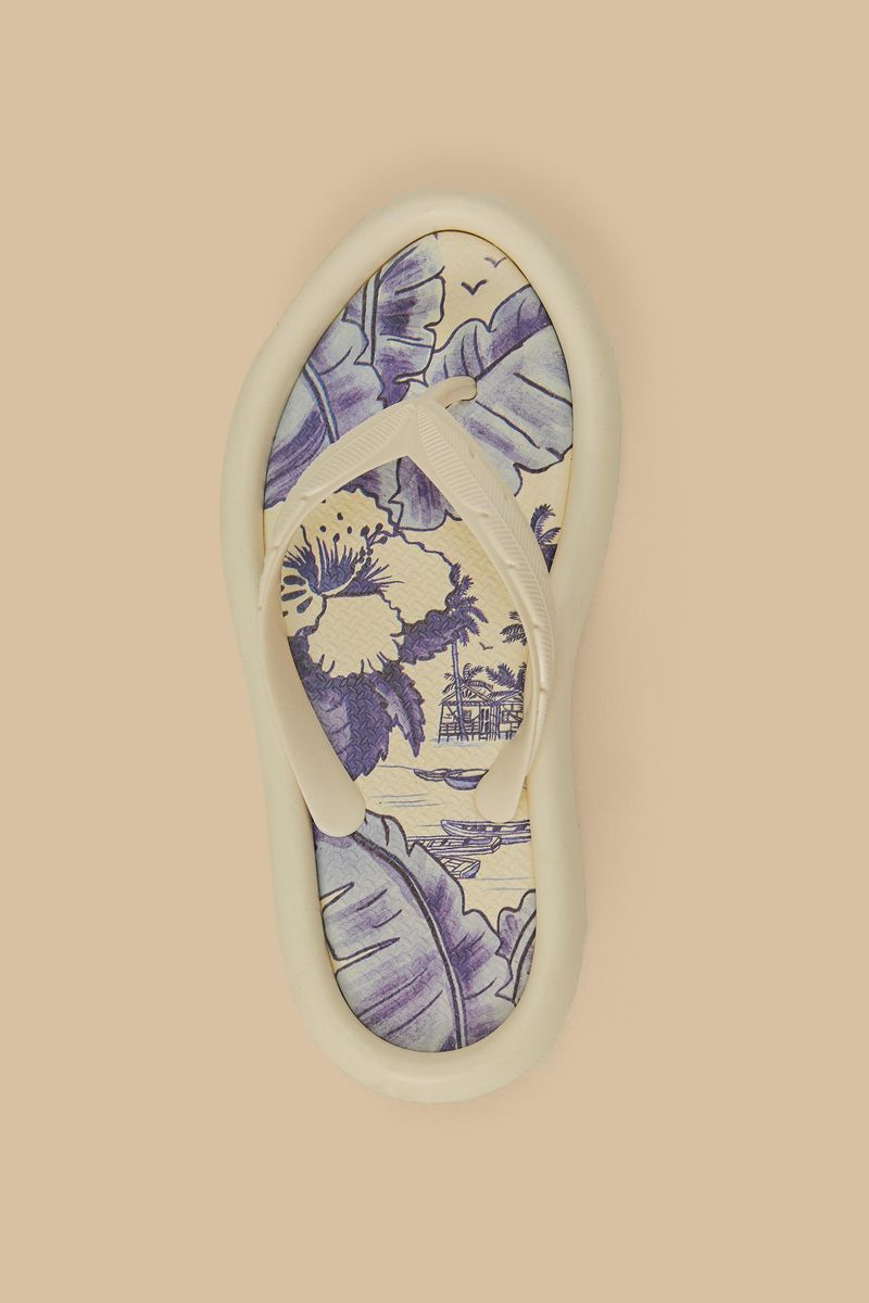 Vista lateral de las sandalias estampadas con detalles botánicos en azul y beige.
