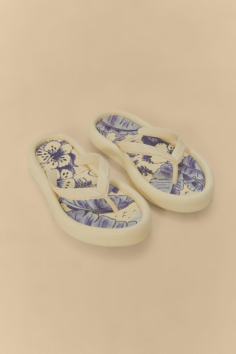 Vista superior de las sandalias estampadas con detalles botánicos en azul y beige.