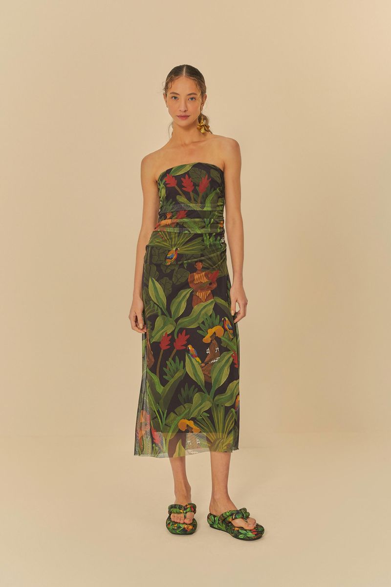 Vista trasera de la modelo con el vestido estampado tropical y sandalias flatform.