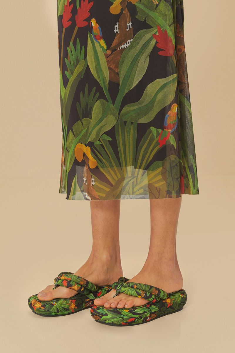 Primer plano del vestido estampado tropical y sandalias flatform.