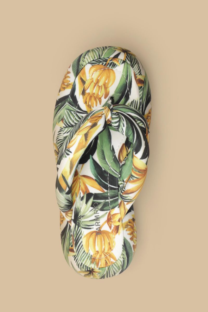 Vista lateral del chinelo flatform mostrando detalles del estampado tropical.