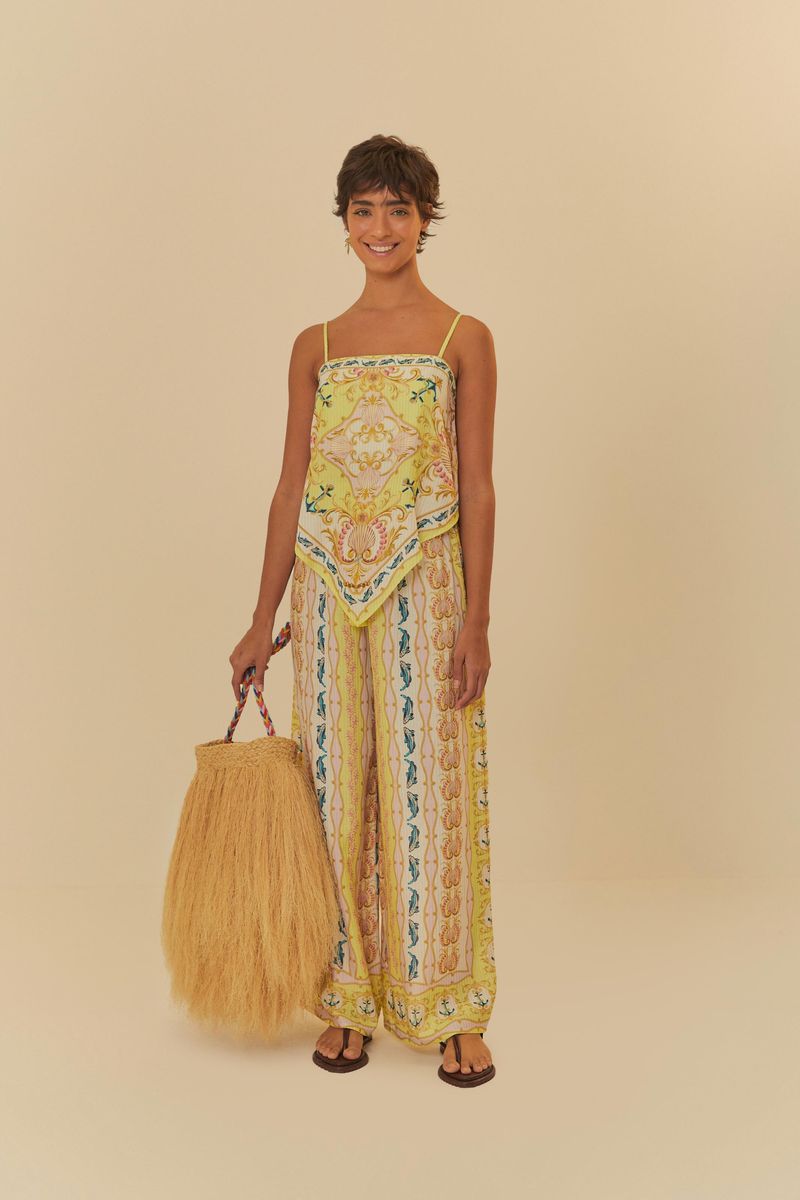 Modelo-usando-pantalon-palazzo-estampado-con-top-a-juego-y-bolso-de-paja.