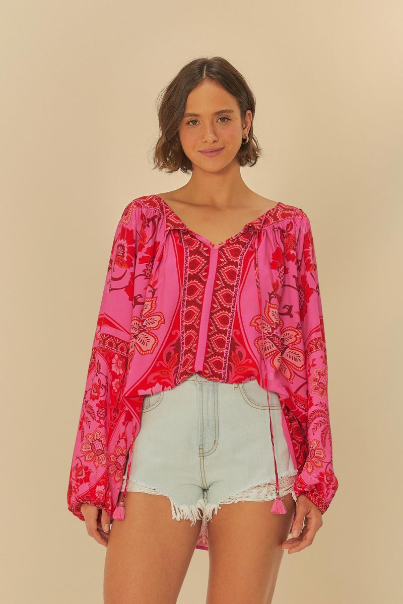 Modelo usando el short vaquero claro con una blusa estampada rosa.