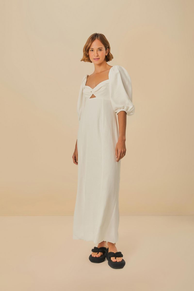 Vestido recto con mangas abullonadas en tejido blanco, visto de lado.