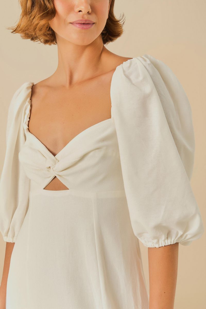 Vestido recto con mangas abullonadas en tejido blanco, visto de espaldas.