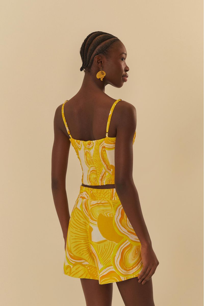 Modelo de espaldas usando un conjunto de top y short estampado en amarillo y blanco.