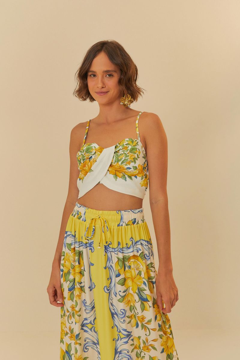 Modelo usando un top estilo crop con estampado floral vibrante y falda larga combinada.