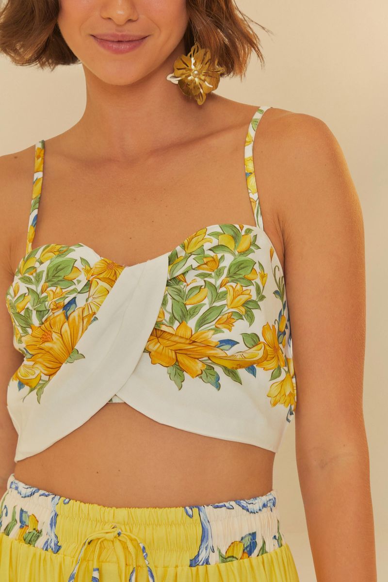 Primer plano del top estilo crop con estampado floral vibrante y diseño de hombros descubiertos.