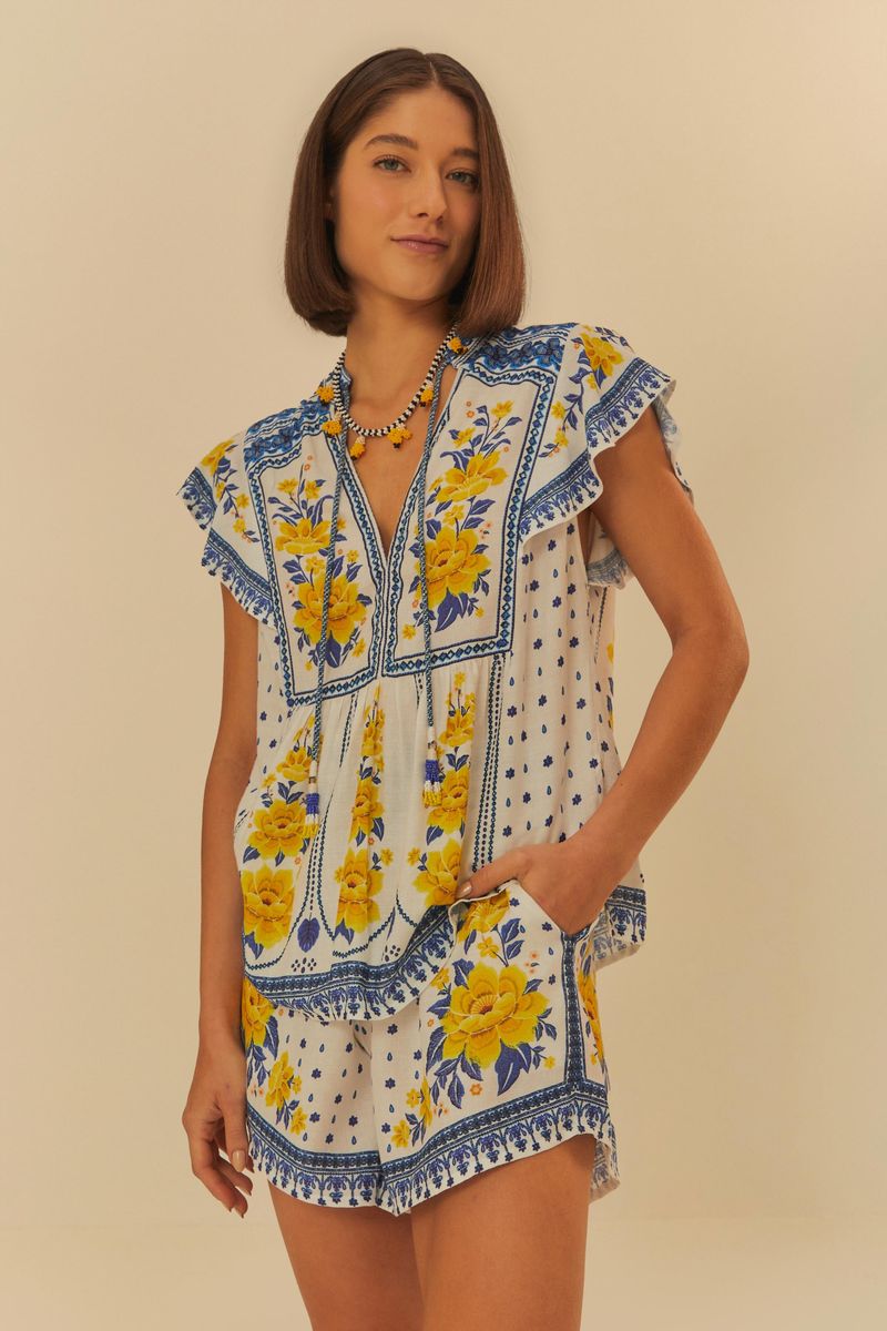 Imagen de un conjunto con blusa y short estampados con flores amarillas y detalles azules.