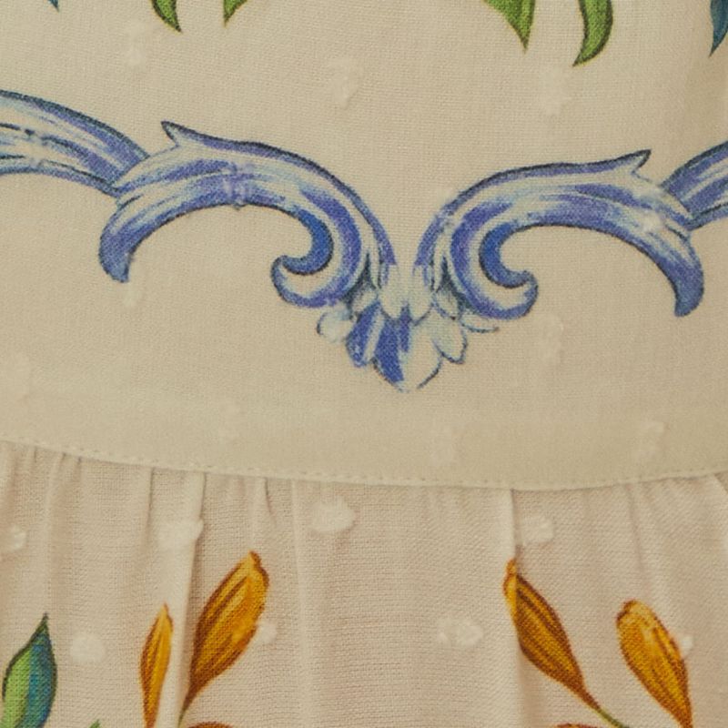 Detalle-del-borde-del-vestido-con-elementos-florales-y-adornos-en-azul.