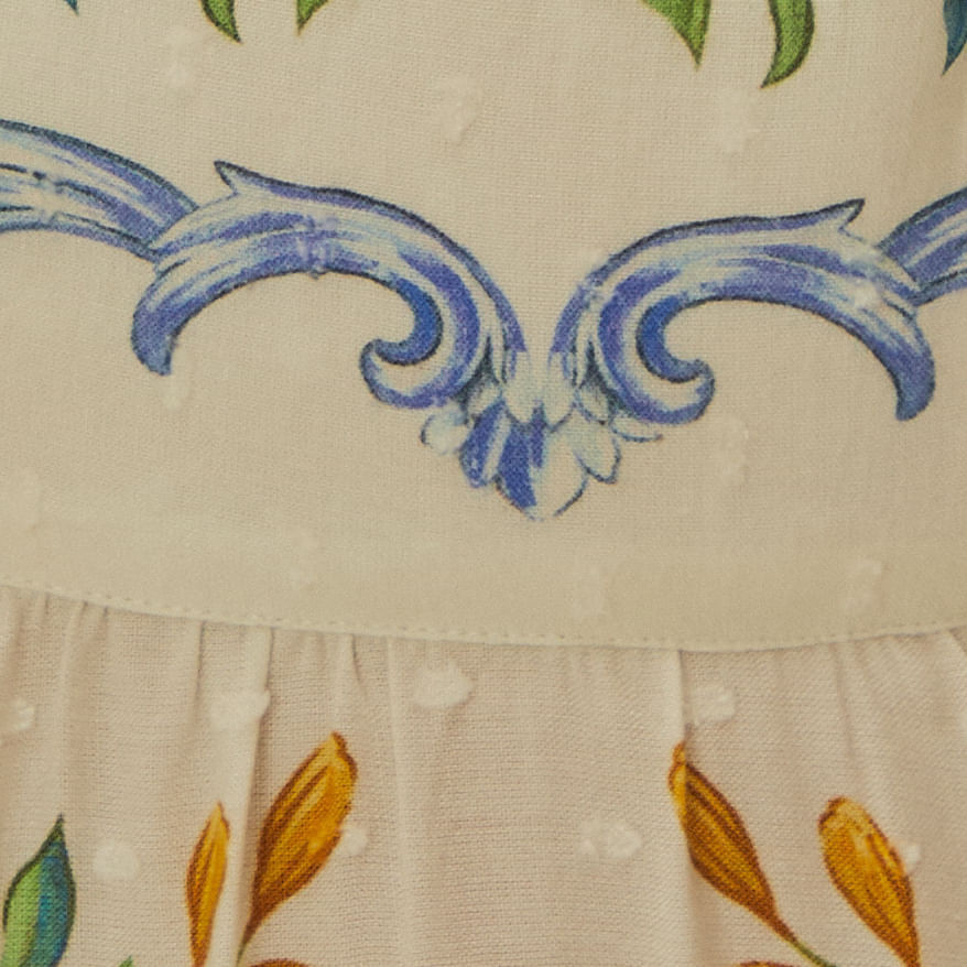 Detalle-del-borde-del-vestido-con-elementos-florales-y-adornos-en-azul.
