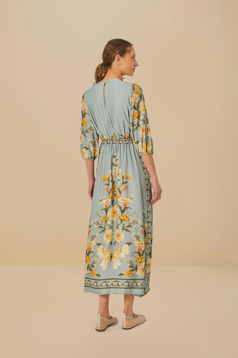 Vista trasera del vestido largo con estampado floral y mangas tipo mariposa.