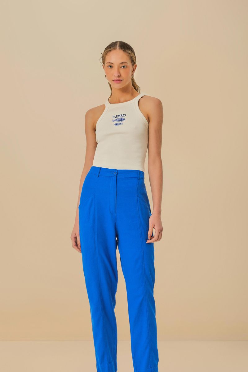Detalle del pantalón azul con pinzas y cintura alta ajustable.