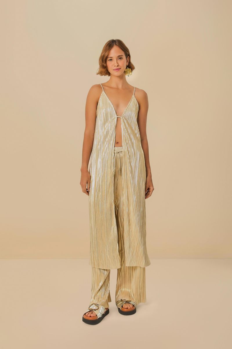 Modelo-usando-un-conjunto-dorado-plisado-con-pantalon-y-top-sobre-un-fondo-beige