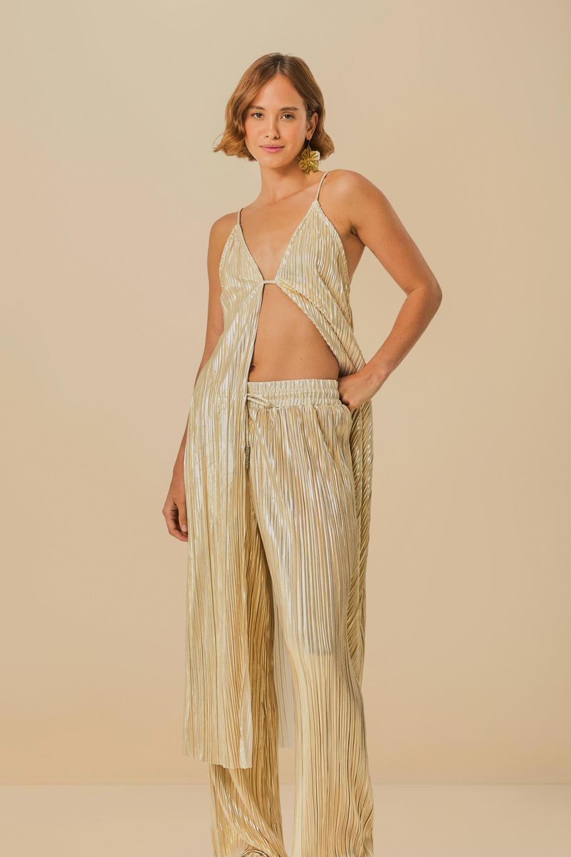 Modelo-de-perfil-mostrando-el-conjunto-plisado-dorado-con-enfoque-en-el-pantalon