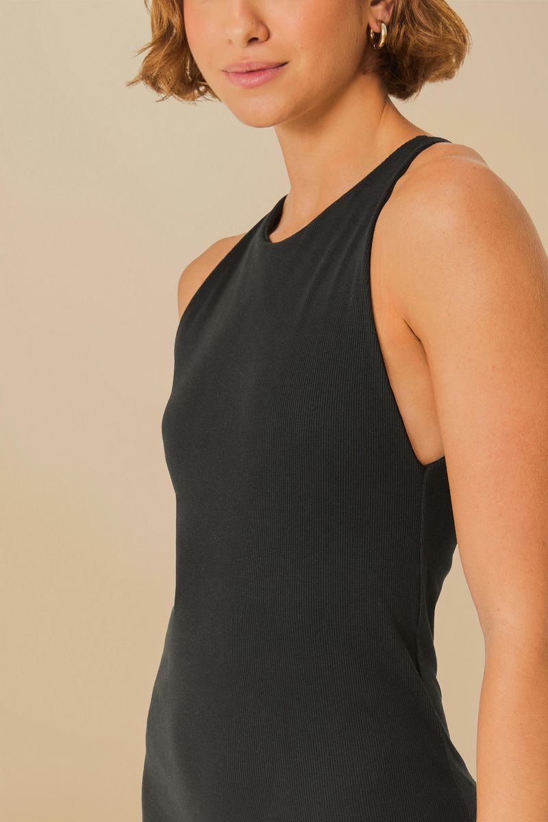 Imagen de un vestido negro con escote en la espalda, longitud midi y tirantes anchos, detalle del tejido y tirantes.