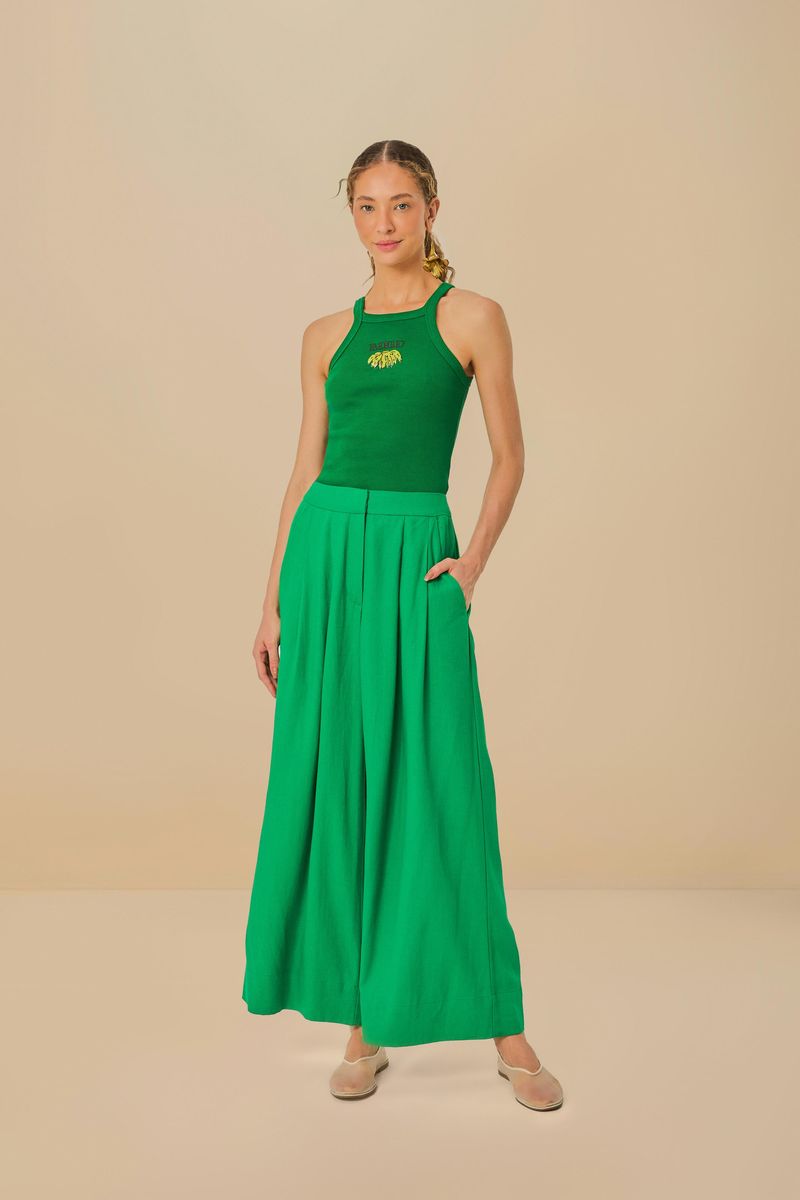 Modelo usando pantalón verde con pliegues y bolsillos, combinado con top verde.