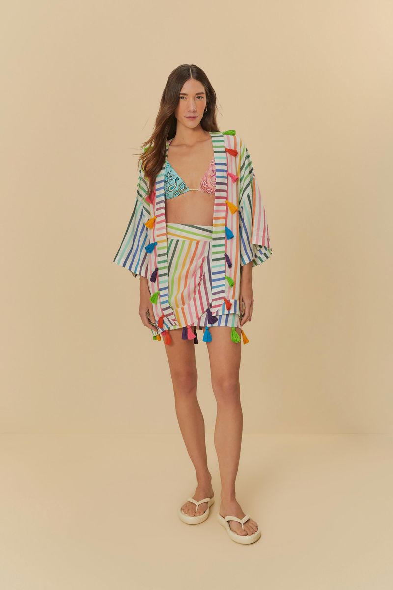 Kimono multicolorido con mangas amplias y pompones vibrantes, mostrado en un modelo.