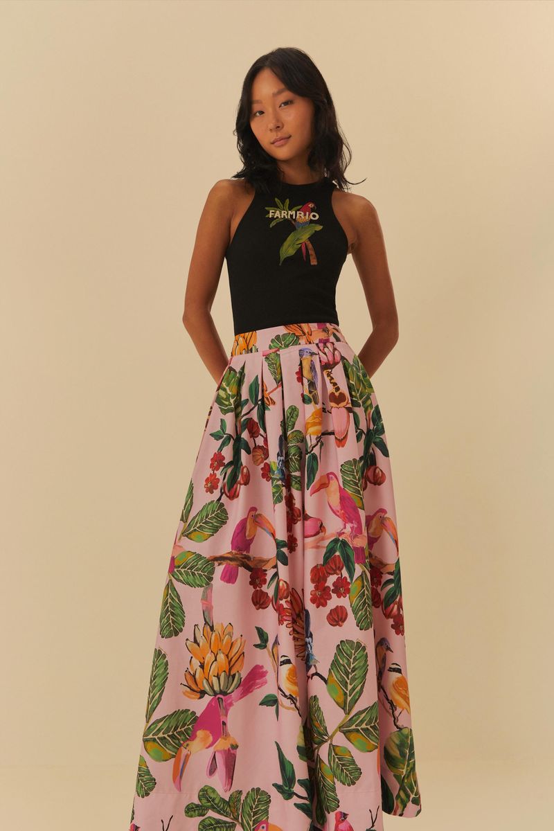 Modelo usando falda larga estampada con blusa negra, vista lateral.