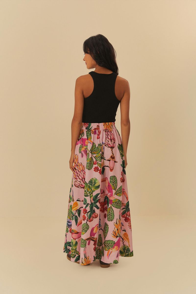 Modelo usando falda larga estampada con blusa negra, vista trasera.