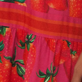 Primer plano del escote en V y tirantes anchos con estampado de fresas.