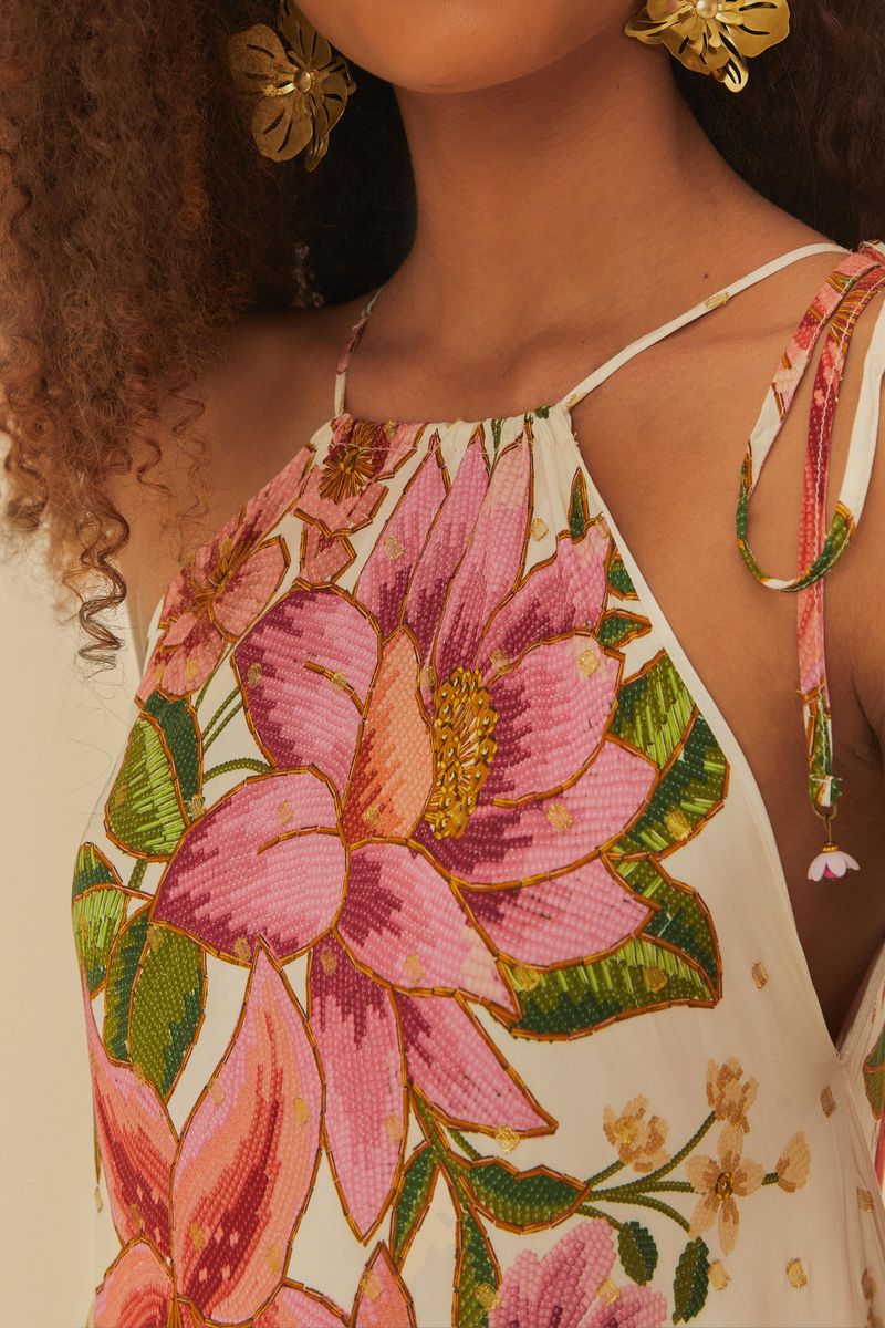 Detalle del escote en V profundo del vestido, con tirantes delgados y estampado floral.