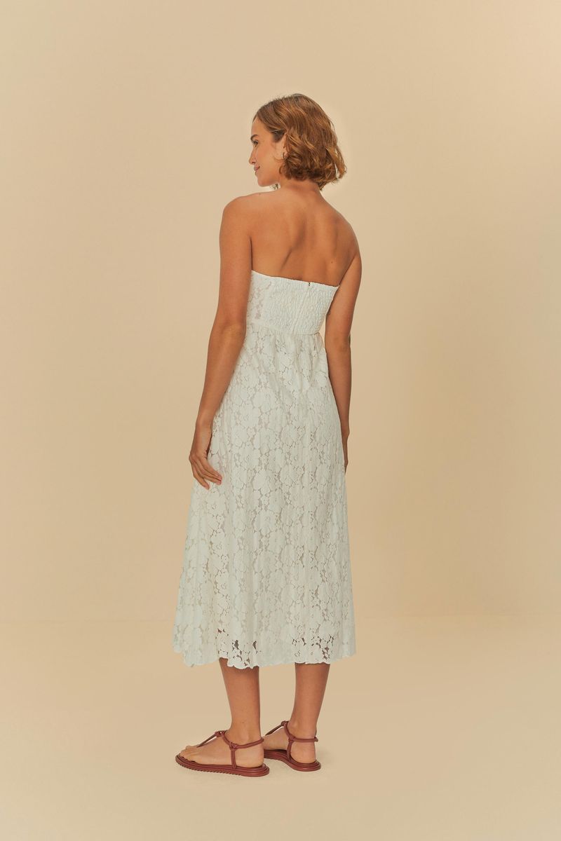 Imagen de un vestido artesanal con encaje floral, mostrado en un fondo neutral, exhibiendo un primer plano de la parte trasera del vestido.