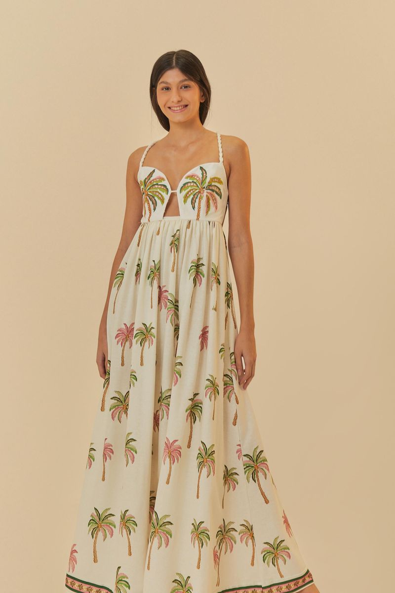 Vestido largo con estampado de palmeras, tirantes delgados y escote profundo, presentado sobre un fondo neutro.