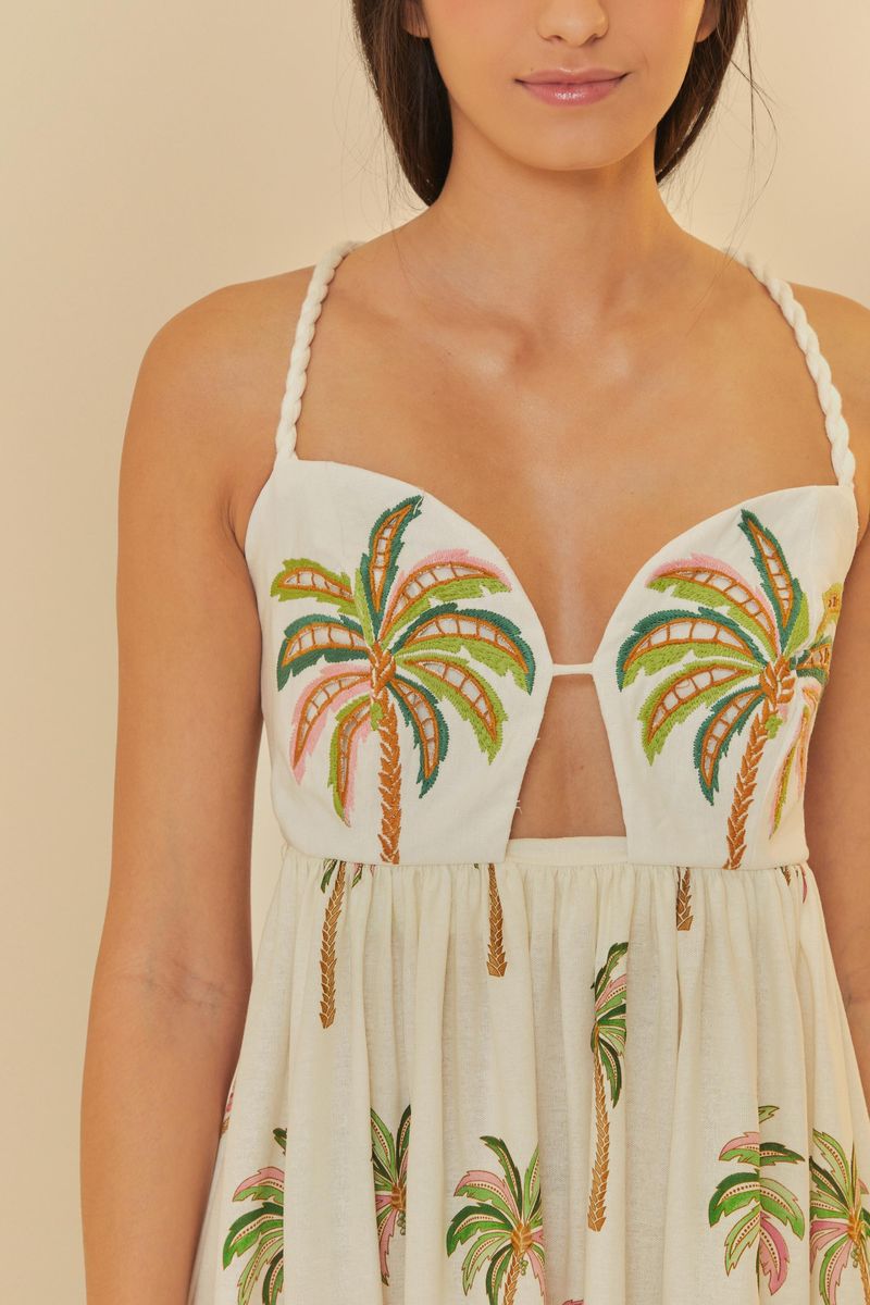 Detalle del corpiño del vestido con bordado de palmeras y escote profundo.