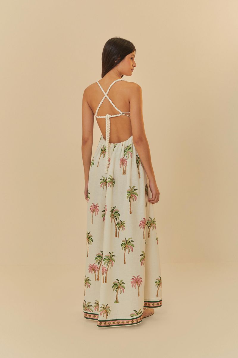Vista posterior del vestido con tirantes cruzados y estampado tropical de palmeras.