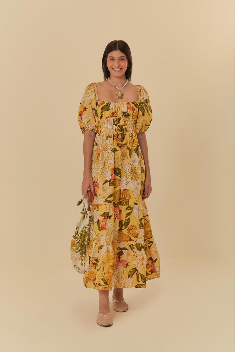 Modelo-usando-vestido-floral-amarillo-con-mangas-abullonadas-sosteniendo-un-bolso.