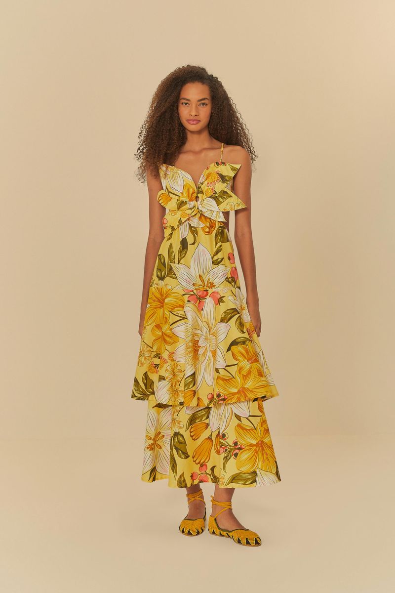 Vestido floral con estampado vibrante de flores amarillas y detalles verdes, exhibido en modelo de espaldas.