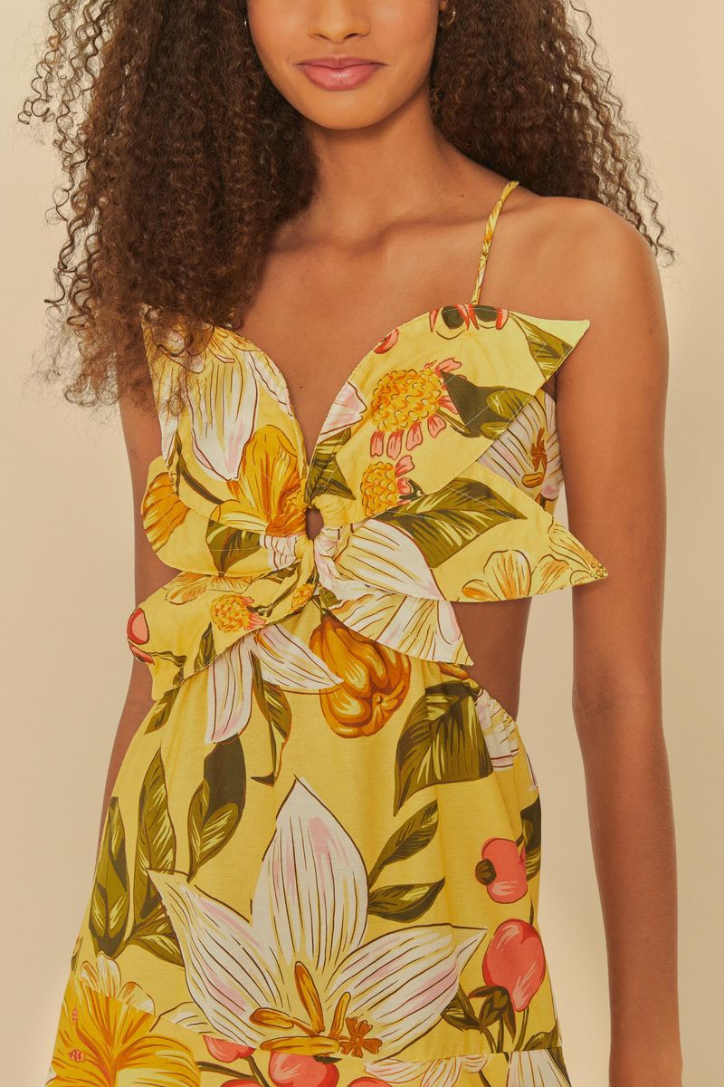 Detalle del escote del vestido floral con estampado vibrante de flores amarillas y detalles verdes.