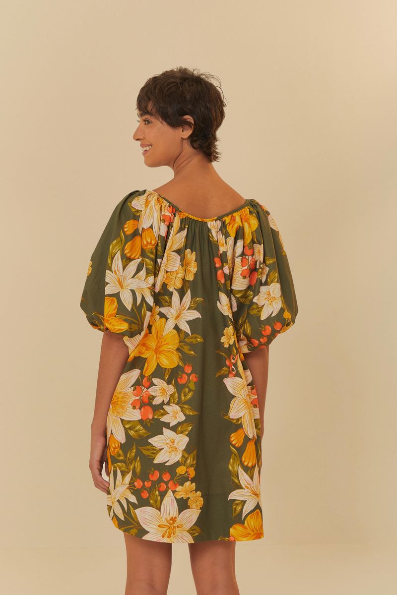 Vista trasera del vestido corto con estampado floral, mostrando la caída y las mangas amplias.