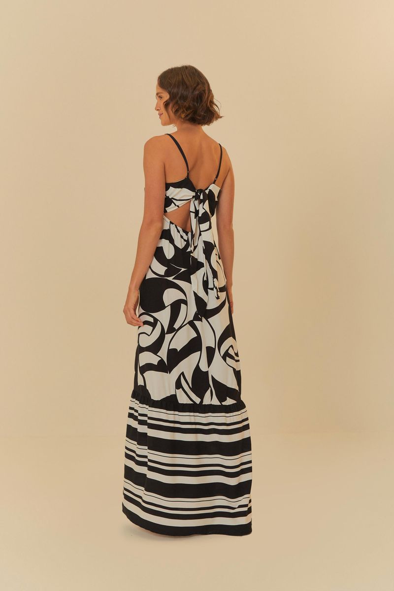Imagen de una mujer vistiendo un vestido largo estampado con tiras delgadas, vista trasera.