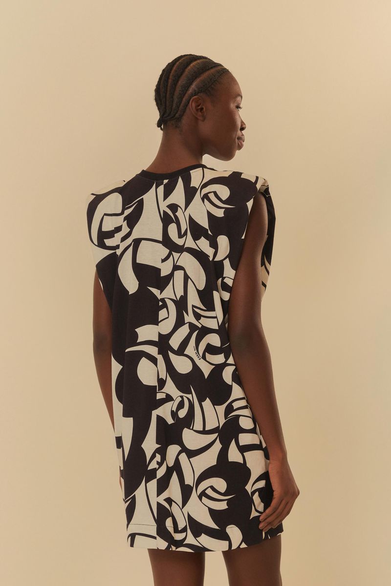 Vista trasera del vestido con estampado abstracto en blanco y negro, destacando la caída y el diseño de las hombreras.