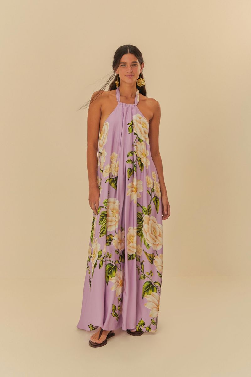 Vestido largo estampado con fondo lila y flores blancas, modelo frente única con tirantes delgados.
