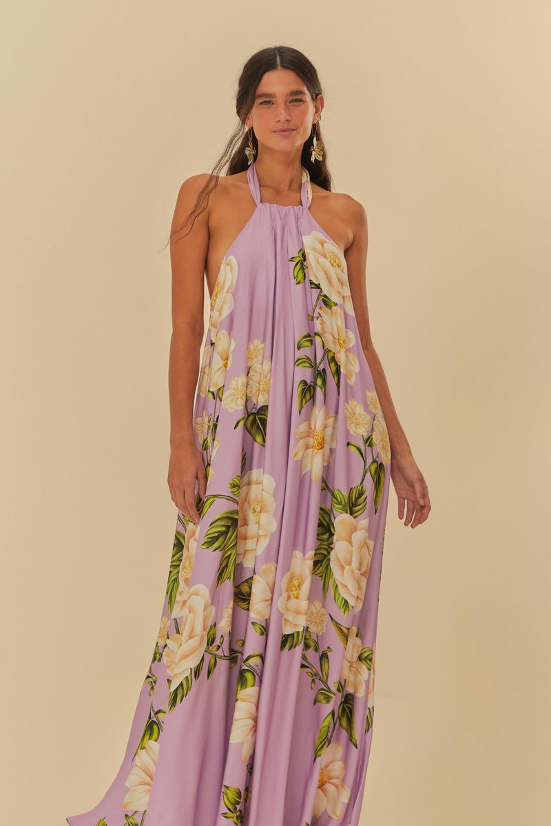 Vista frontal del vestido largo estampado con fondo lila y flores blancas, destacando la caída fluida.