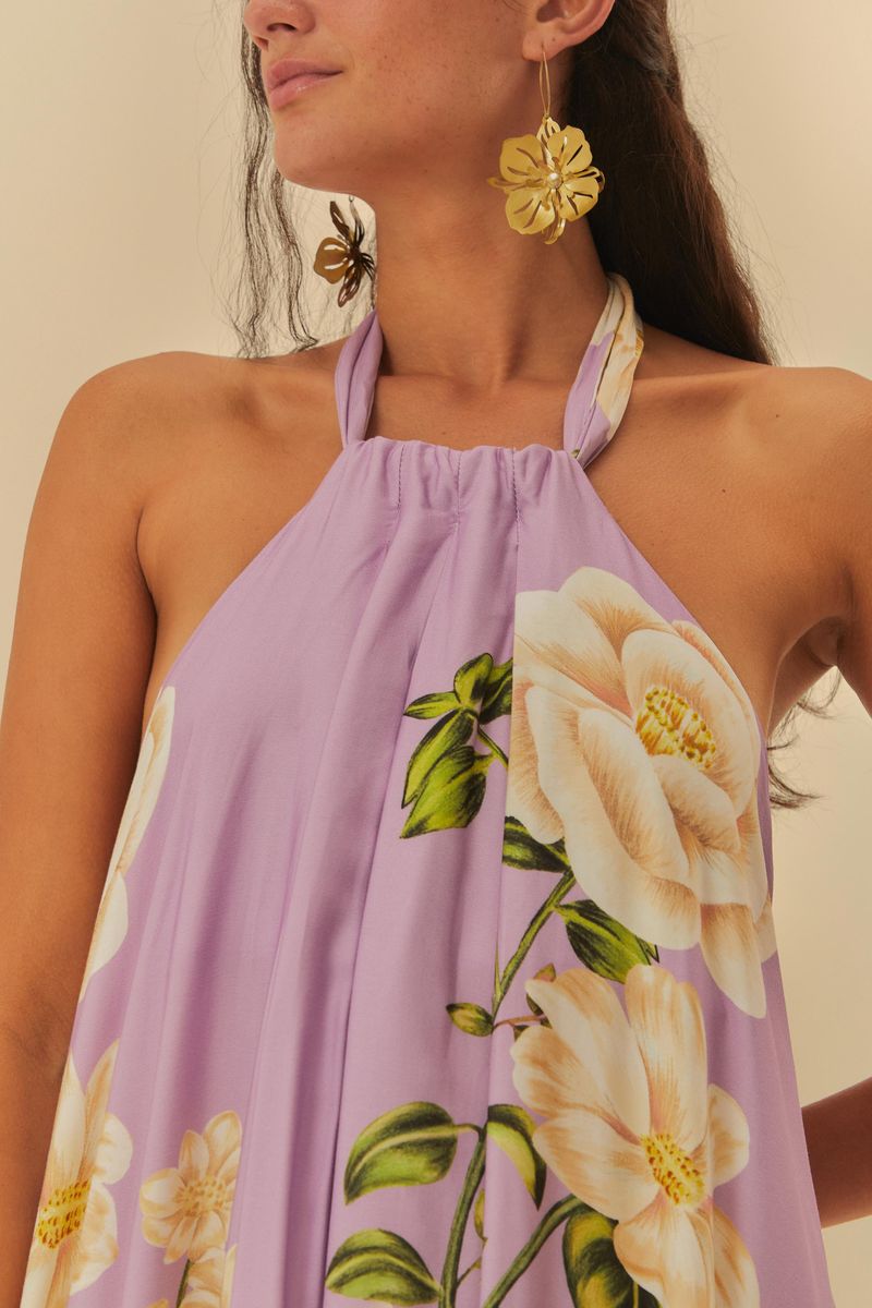 Detalle del escote frente única del vestido estampado con fondo lila y flores blancas.