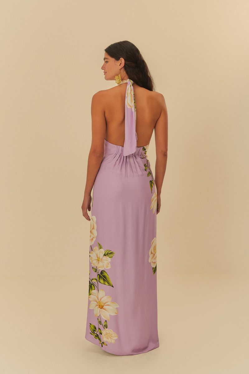 Vista trasera del vestido largo estampado con fondo lila y flores blancas, mostrando el ajuste en la cintura.