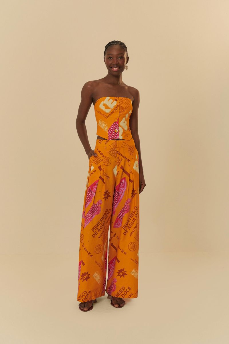 Modelo-de-frente-usando-pantalon-palazzo-naranja-con-estampado-vibrante-manos-en-los-bolsillos