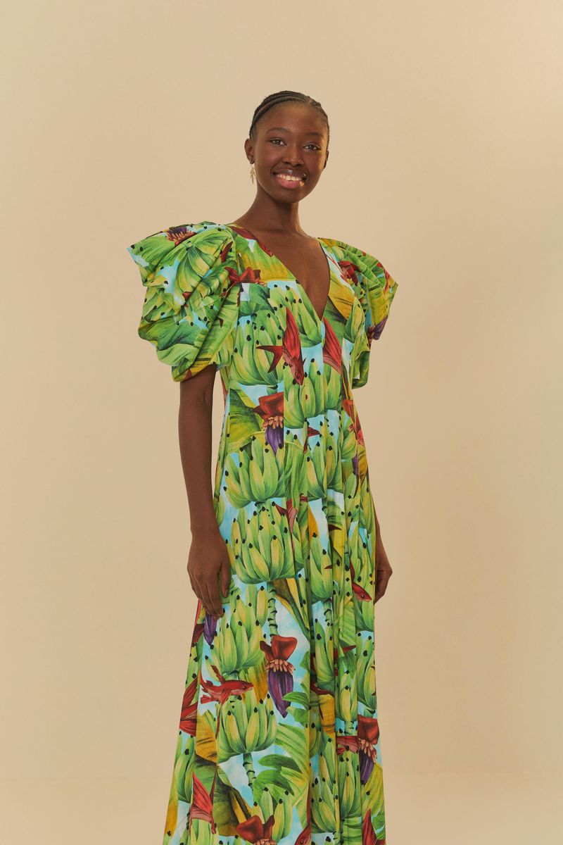Vista lateral del vestido midi con estampado tropical, destacando la caída fluida y las mangas voluminosas.